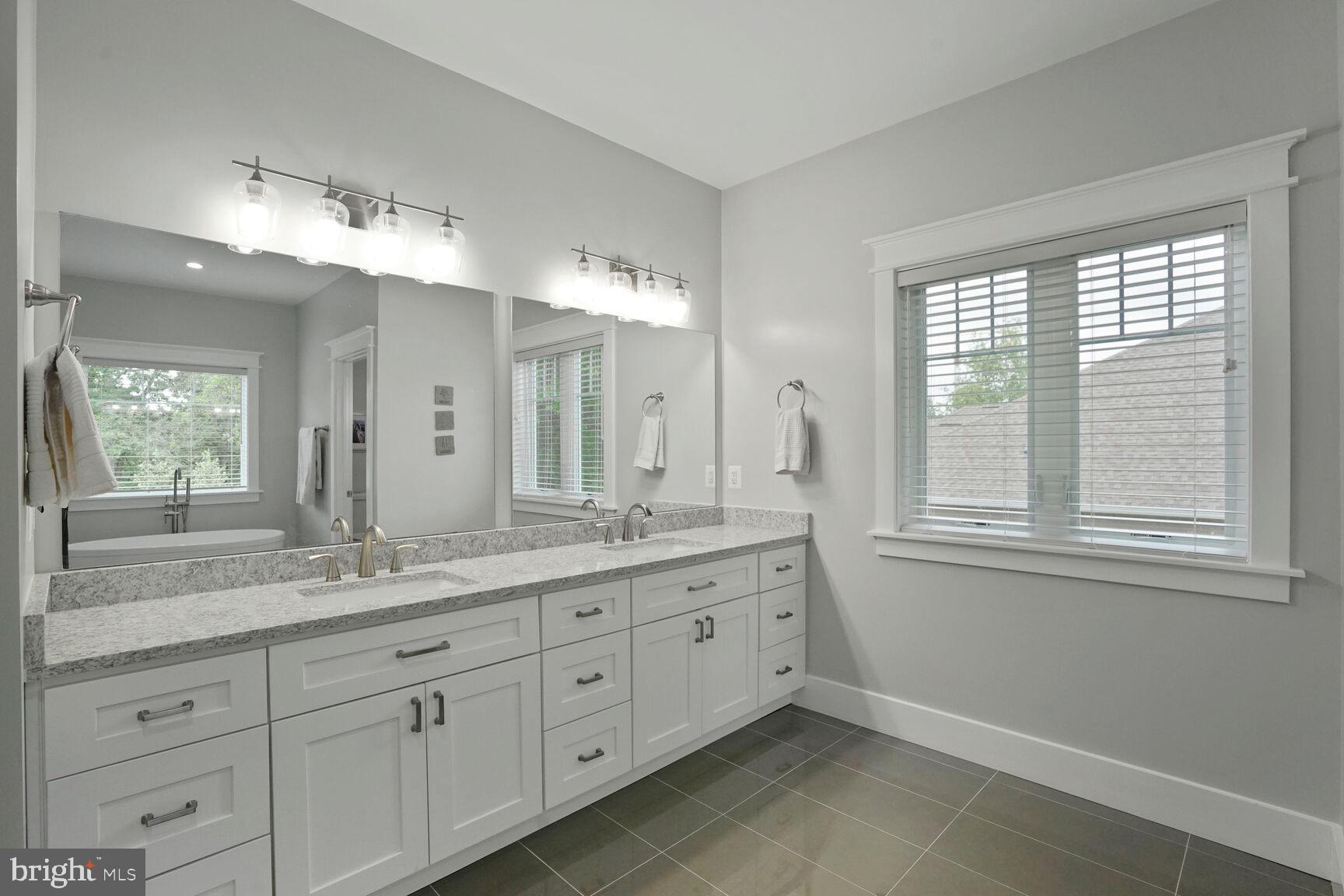 7045 Barbara Road Alexandria, VA 22315 - Photo 32 of 57 a spacious bathroom with double sink a mirror a window and a shower