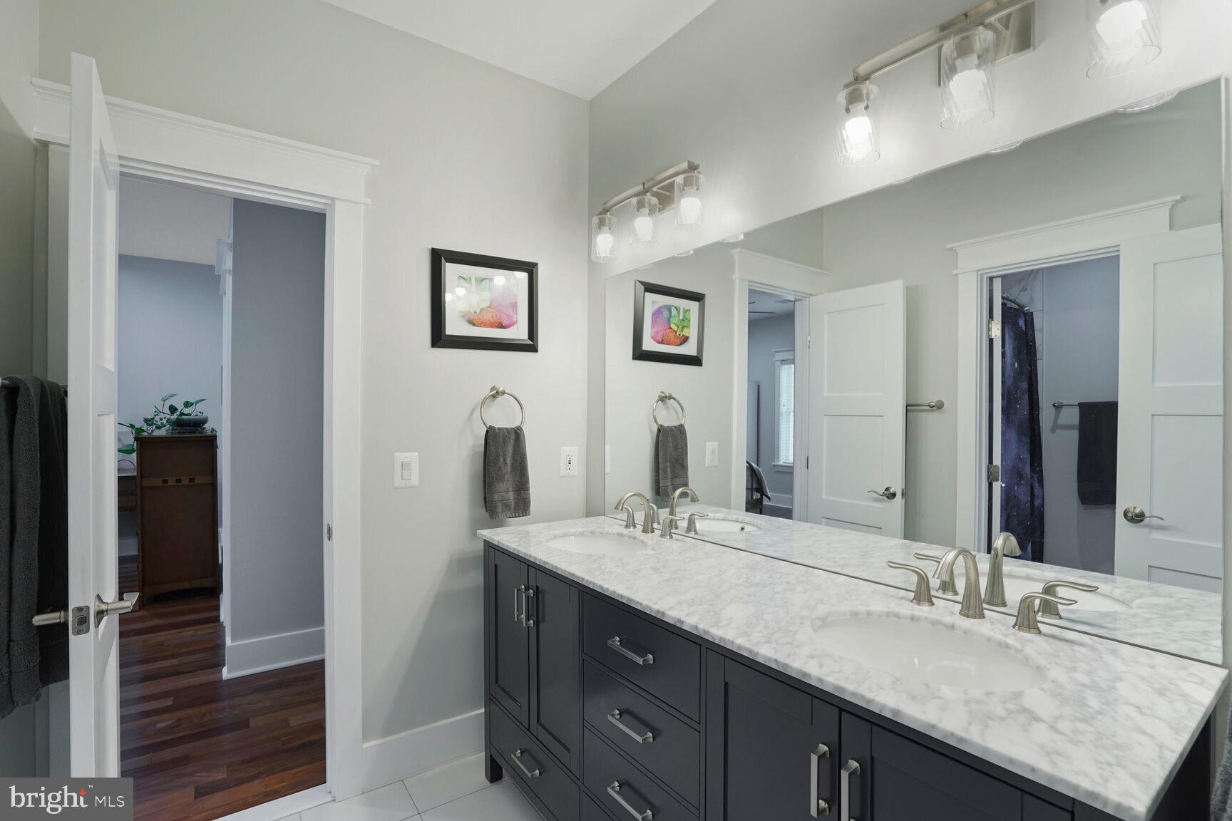 7045 Barbara Road Alexandria, VA 22315 - Photo 38 of 57 a bathroom with double vanity sinks a vanity and a large mirror