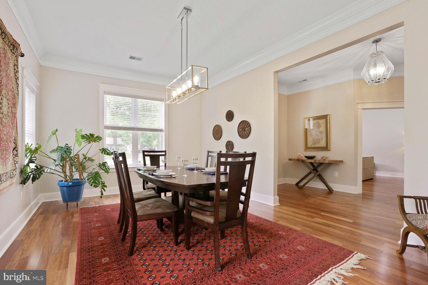 7045 Barbara Road Alexandria, VA 22315 - Photo 7 of 57 a view of a dining room and livingroom with furniture wooden floor a rug a potted plant and a chandelier