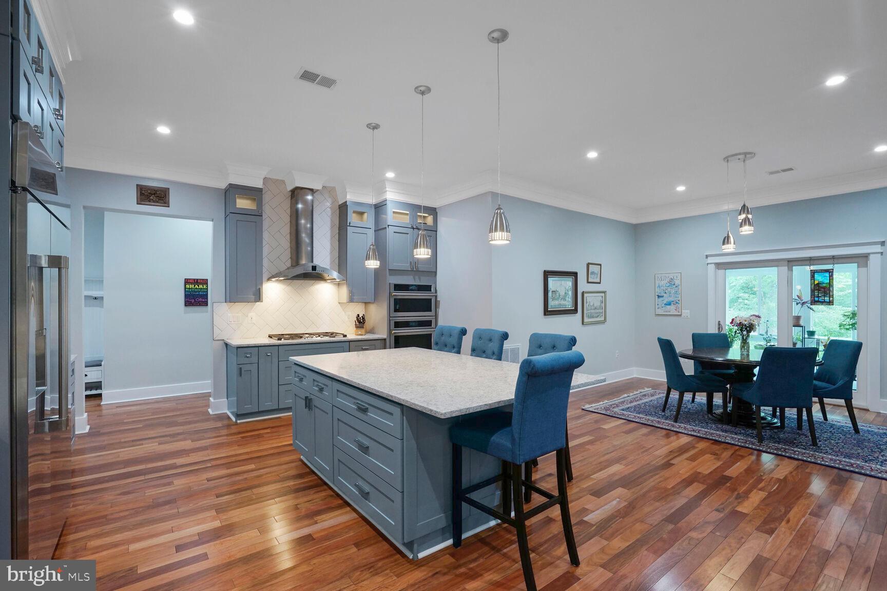 7045 Barbara Road Alexandria, VA 22315 - Photo 9 of 57 a large kitchen with stainless steel appliances a dining table chairs and wooden floor