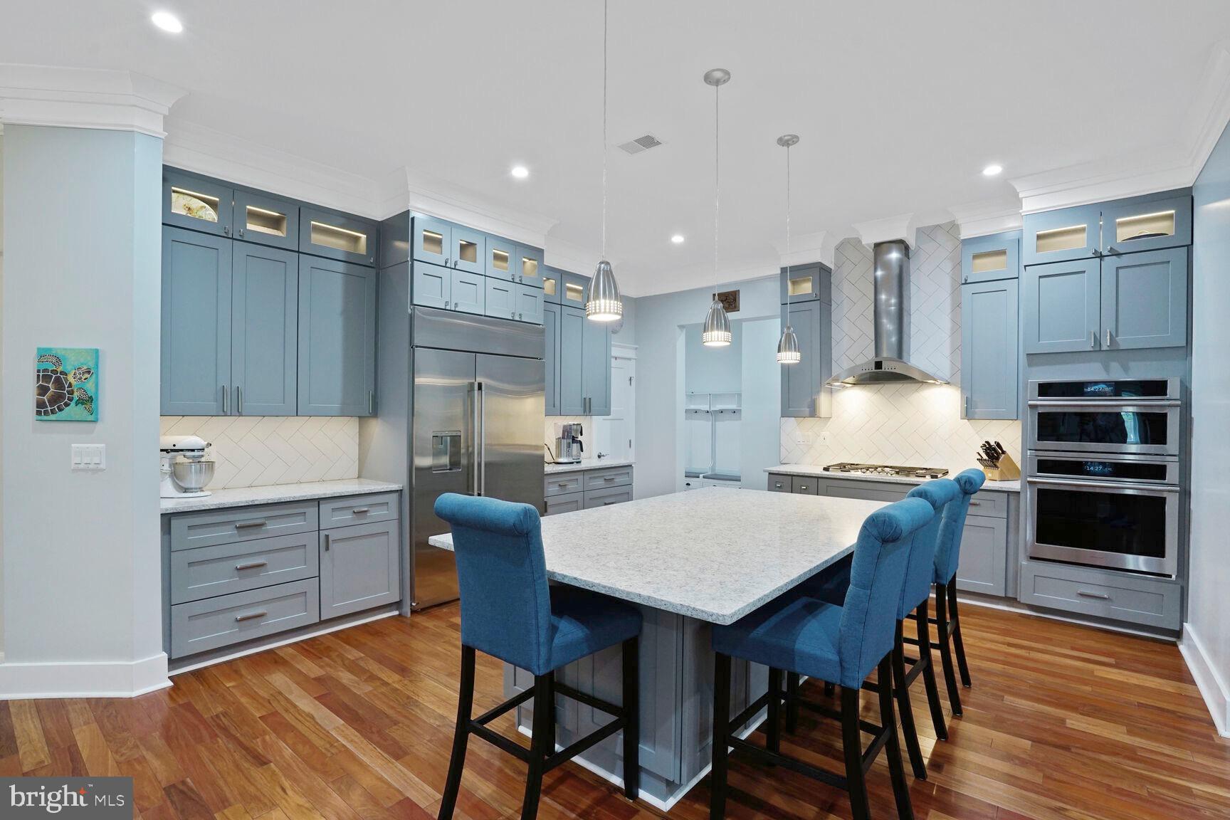 7045 Barbara Road Alexandria, VA 22315 - Photo 10 of 57 a kitchen with granite countertop a table chairs stainless steel appliances and wooden floor