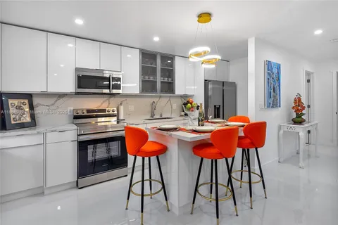 a living room with blue couches chair and a flat screen tv