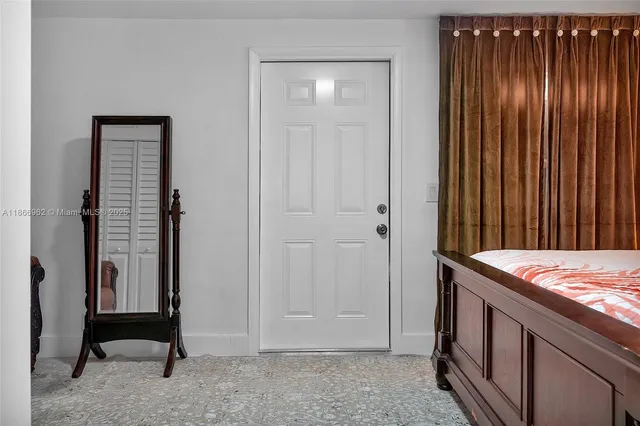 a view of a yard in front of a house with plants and a large tree