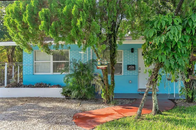 a view of a backyard with table and chairs and a large tree