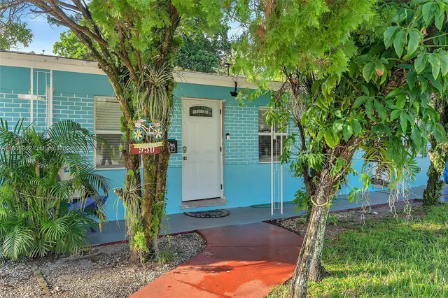 a view of a house with backyard and a tree