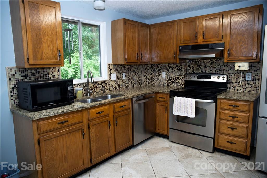 3307 Piney Grove Road Charlotte, NC 28212 - Photo 20 of 48 a kitchen with stainless steel appliances granite countertop white cabinets granite counter tops and a window
