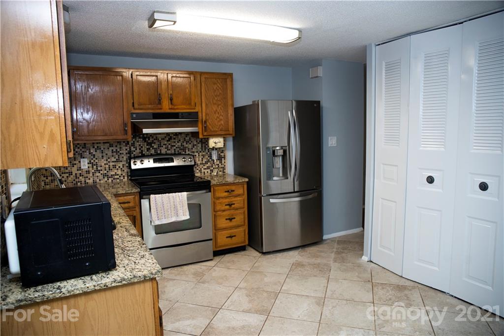 3307 Piney Grove Road Charlotte, NC 28212 - Photo 23 of 48 a kitchen with stainless steel appliances granite countertop a refrigerator stove and sink