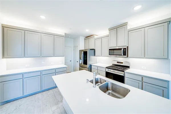 a kitchen with stainless steel appliances granite countertop a sink stove and refrigerator