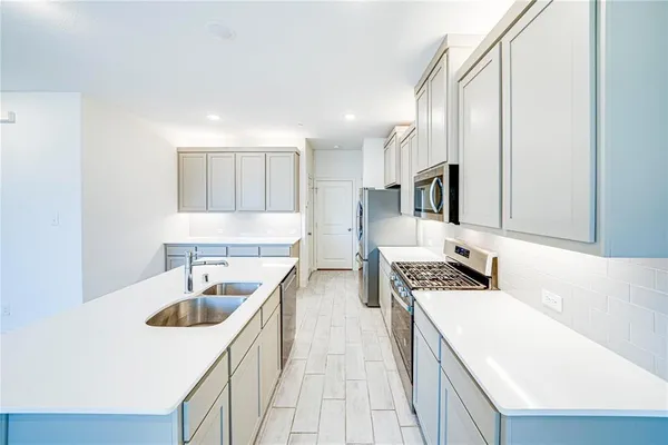 a kitchen with a stove a sink and a refrigerator