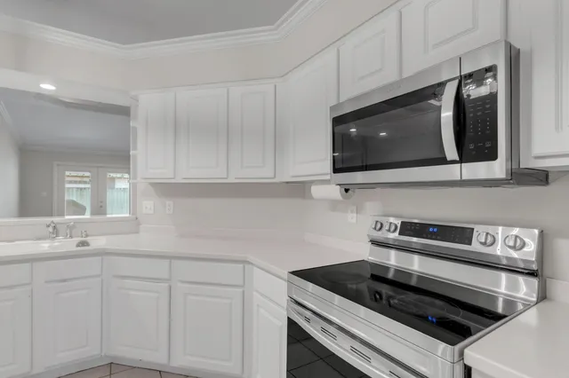 a kitchen with kitchen island granite countertop cabinets and stainless steel appliances