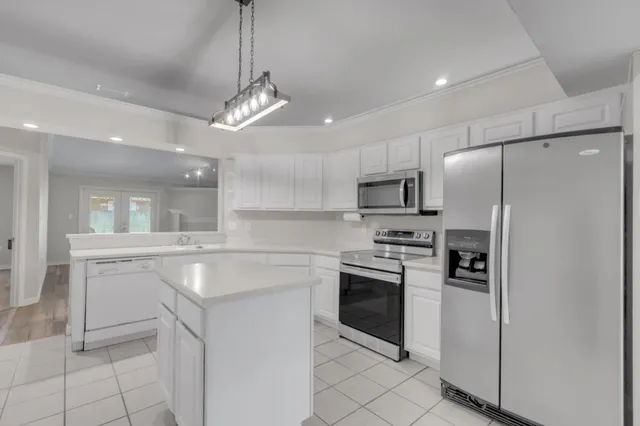 a kitchen with white cabinets stainless steel appliances and sink