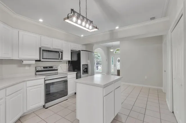 a kitchen with stainless steel appliances granite countertop a refrigerator and a stove top oven