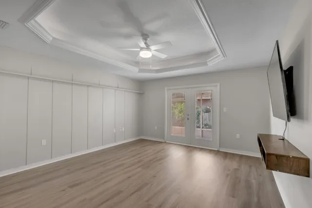 an empty room with wooden floor and windows