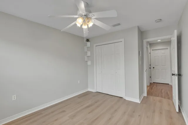 a view of an empty room with a chandelier fan