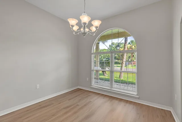 a view of dining room with wooden floor and a large window