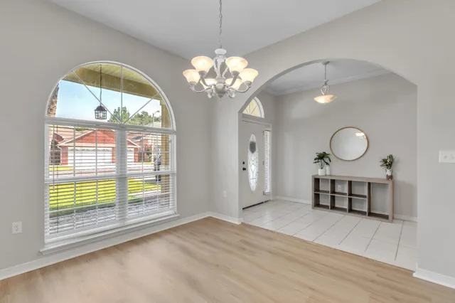a view of a room with wooden floor and chandelier