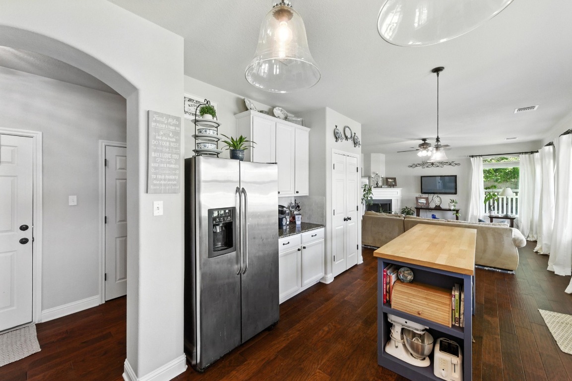 316 Caraway Kyle, TX 78640 - Photo 15 of 39 Kitchen with stainless steel fridge with ice dispenser, arched walkways, white cabinets, granite countertops