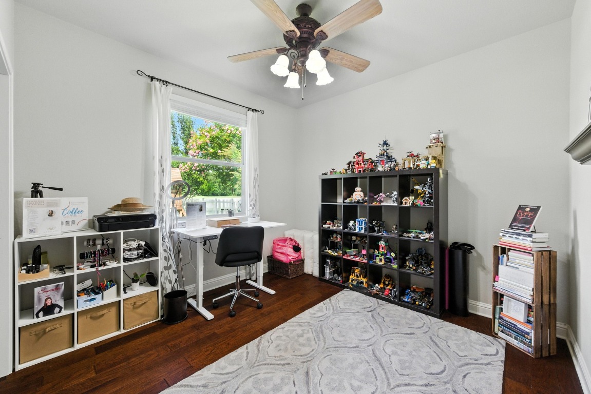 316 Caraway Kyle, TX 78640 - Photo 28 of 39 Downstairs bedroom currently used as office with wood floors and ceiling fan