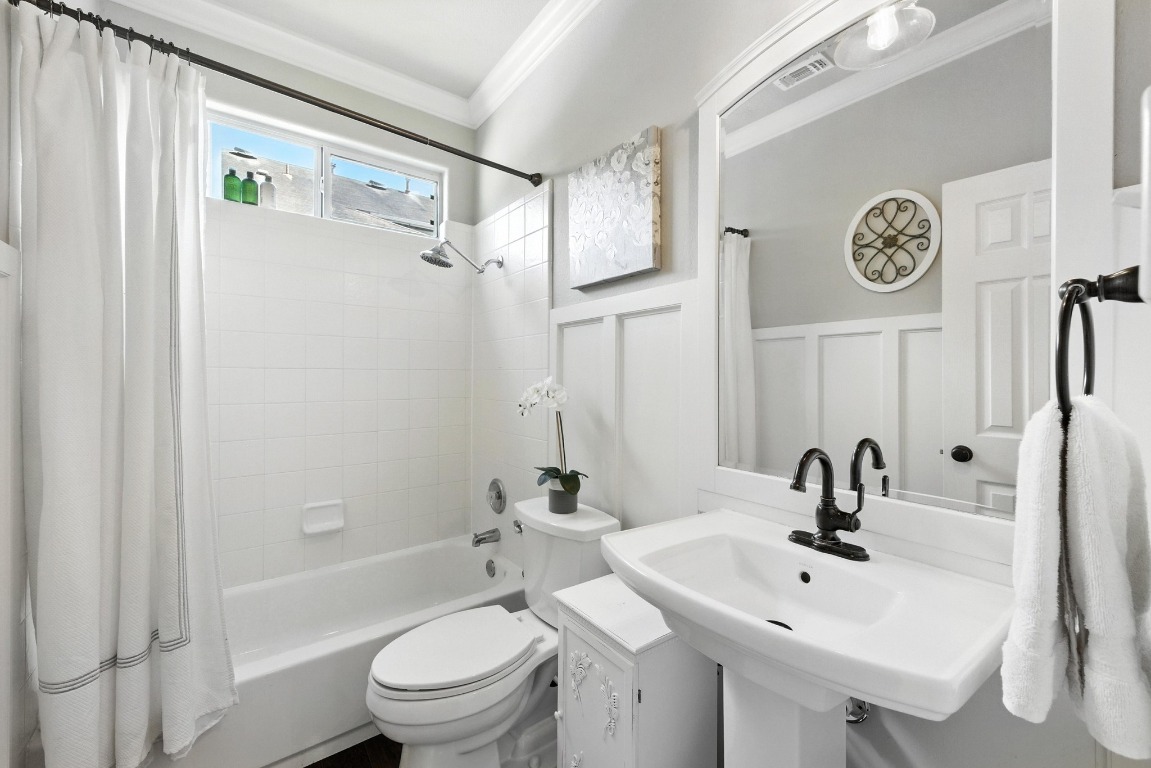 316 Caraway Kyle, TX 78640 - Photo 31 of 39 Full bathroom featuring ornamental molding, shower / tub combo, a wainscoted wall, and a decorative wall