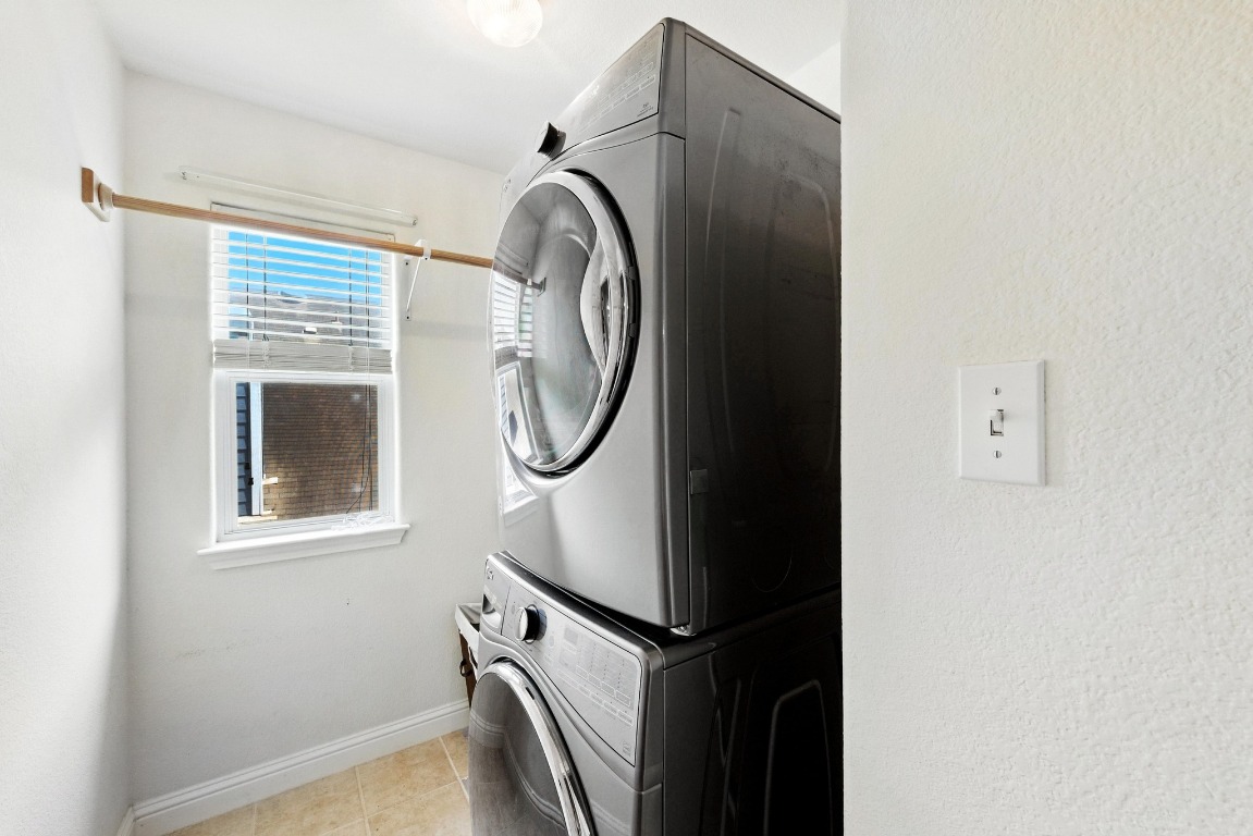 316 Caraway Kyle, TX 78640 - Photo 32 of 39 Laundry room featuring stacked washer / dryer and light tile patterned floors