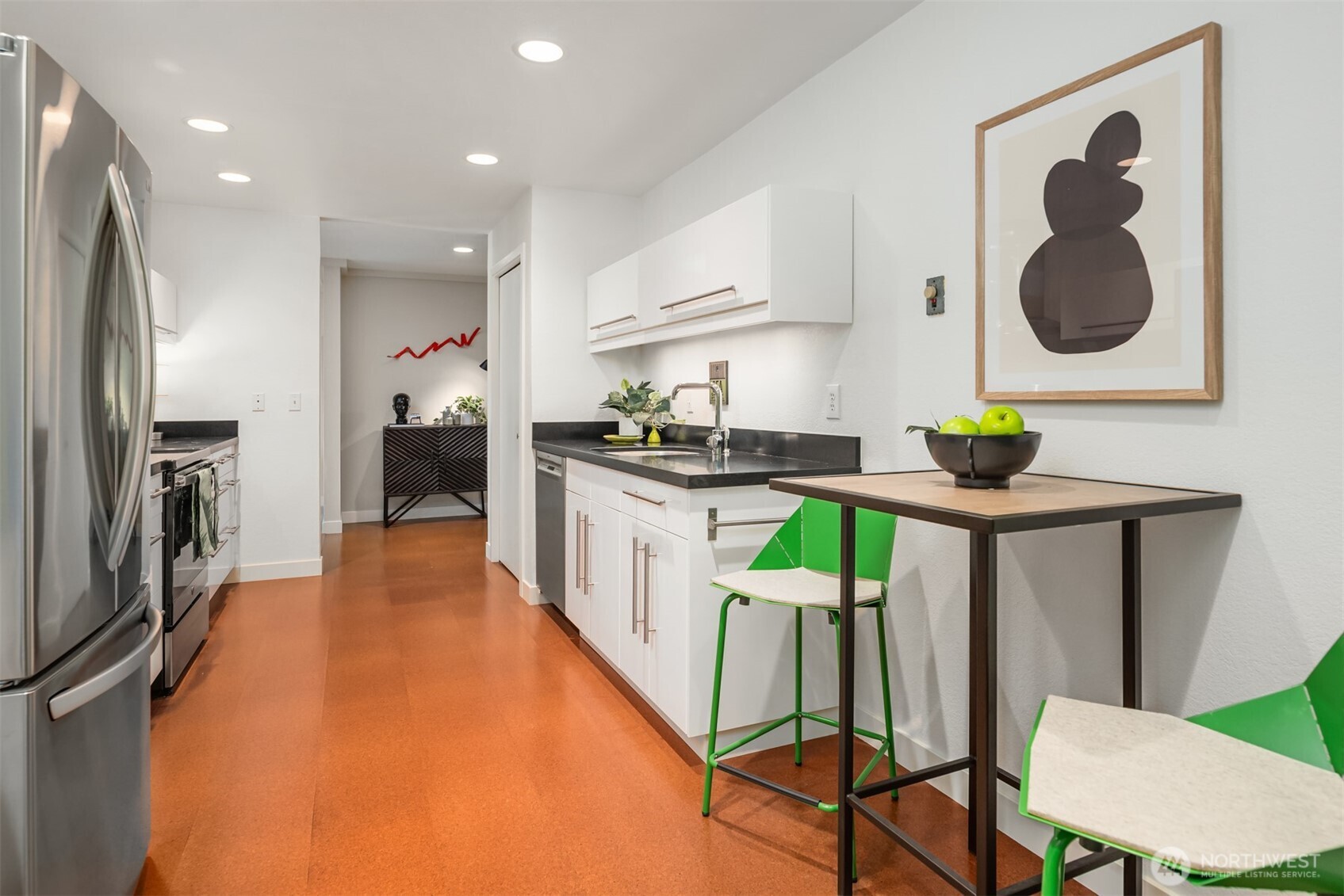701 17th Avenue, Unit 305 Seattle, WA 98122 - Photo 17 of 36 a kitchen with kitchen island stainless steel appliances a stove refrigerator sink and a stove