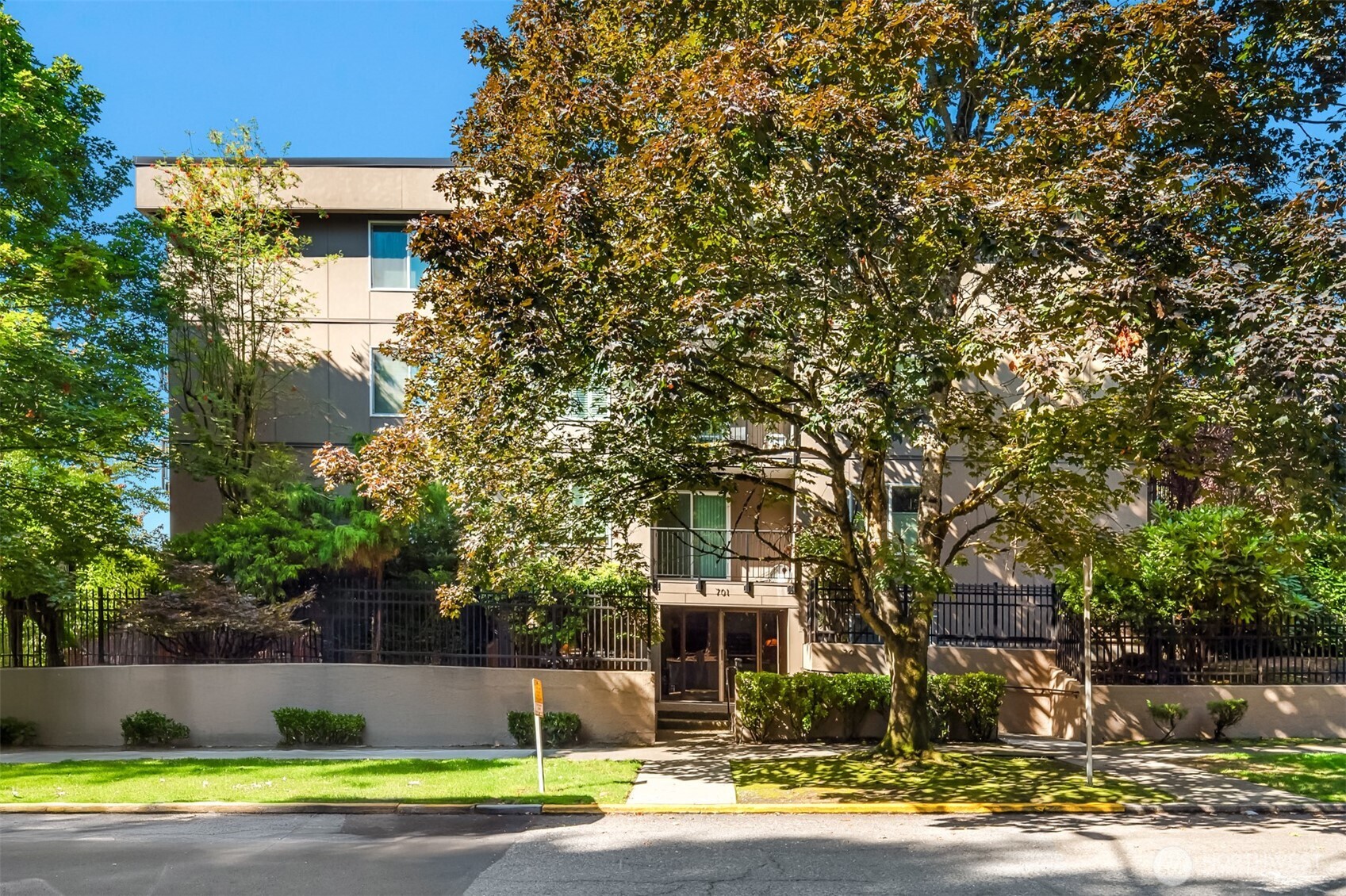 701 17th Avenue, Unit 305 Seattle, WA 98122 - Photo 34 of 36 a front view of a house with a yard and trees