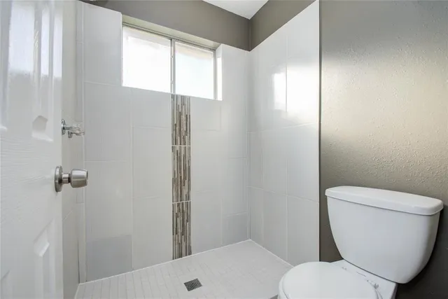 a white toilet sitting next to a bathroom sink and tub