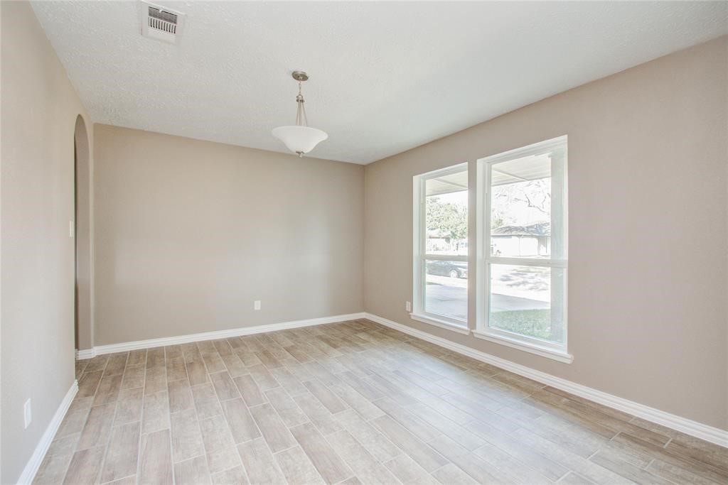 10510 Rancho Bernardo Lane Sugar Land, TX 77498 - Photo 4 of 27 an empty room with wooden floor and windows