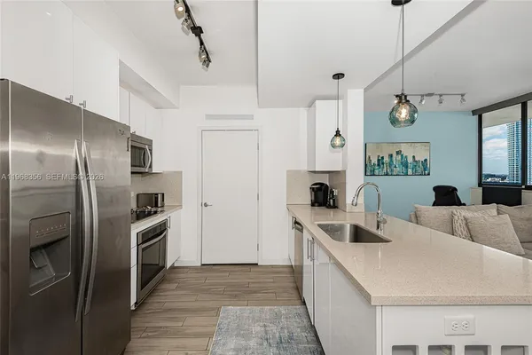 a kitchen that has a lot of cabinets and stainless steel appliances