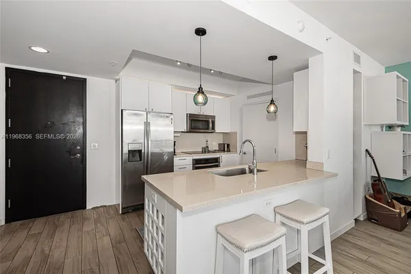 a kitchen with stainless steel appliances a refrigerator sink and microwave