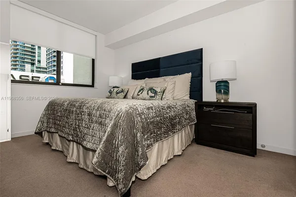 a bedroom with a bed and a night stand
