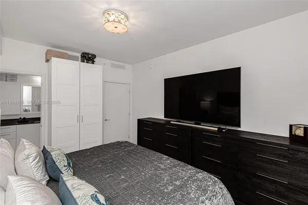 a bedroom with a bed and a flat screen tv