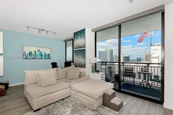 a living room with furniture and a floor to ceiling window
