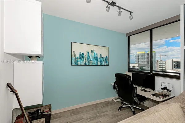 a view of a workspace with furniture and a window