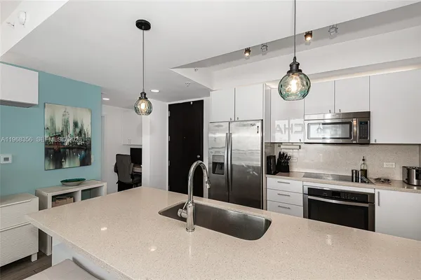 a kitchen with stainless steel appliances granite countertop a sink a stove and a refrigerator