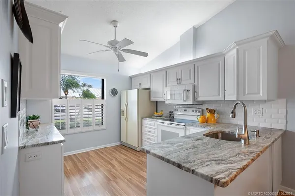 a kitchen with stainless steel appliances granite countertop a sink refrigerator and microwave