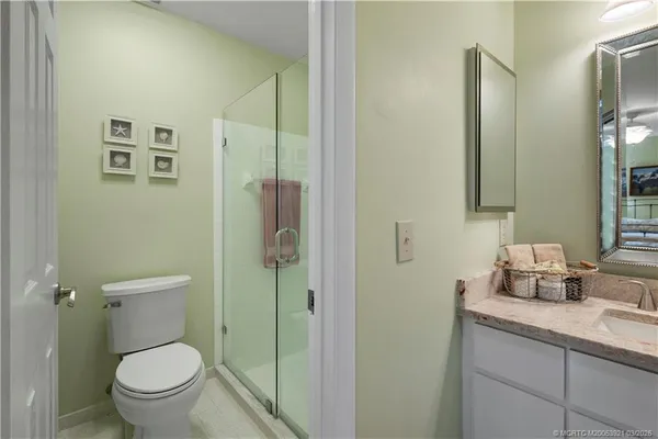 a bathroom with a granite countertop toilet a sink and a mirror