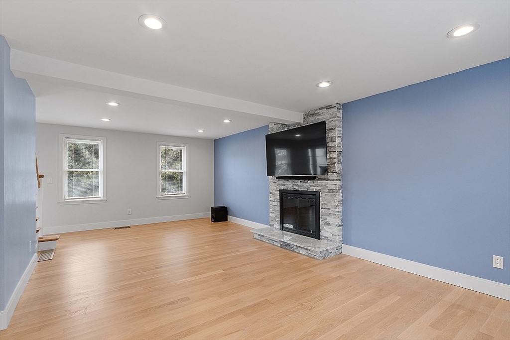 22 Coleman Road Groveland, MA 01834 - Photo 11 of 35 an empty room with wooden floor fireplace and a window