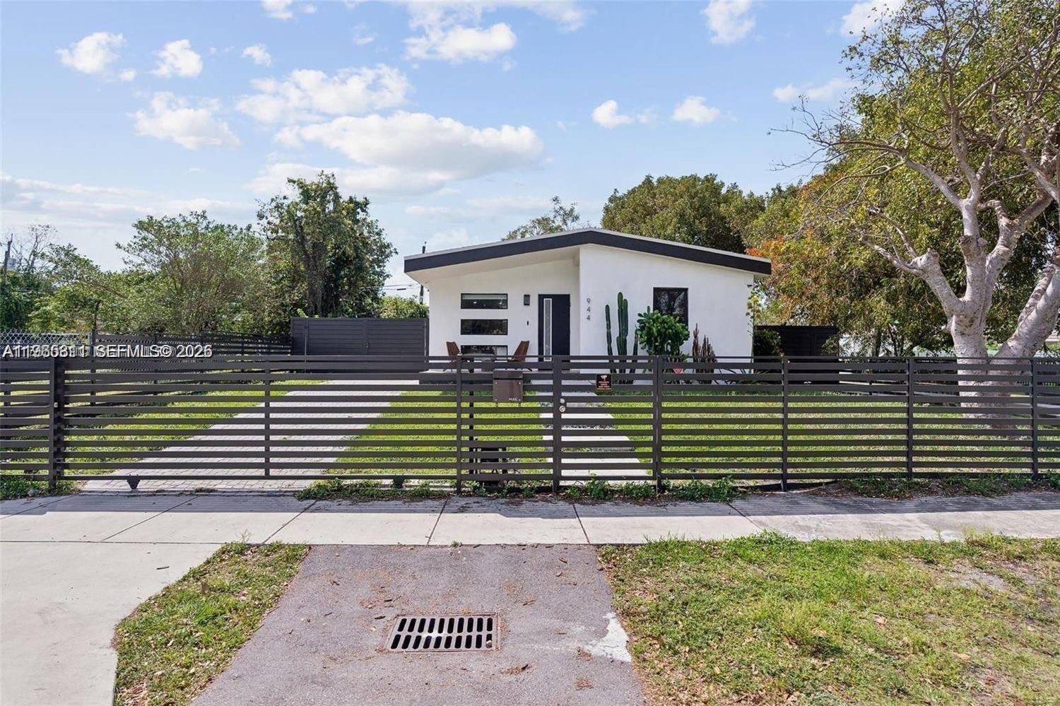 944 Northwest 64th Street Miami, FL 33150 - Photo 1 of 19 a front view of a house with a garden