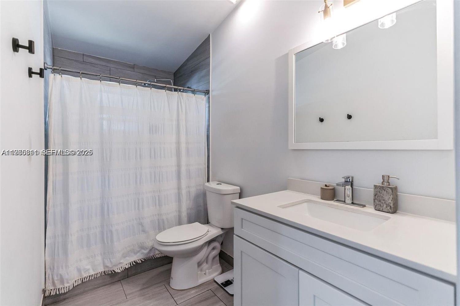 944 Northwest 64th Street Miami, FL 33150 - Photo 11 of 19 a bathroom with a toilet a sink and a shower