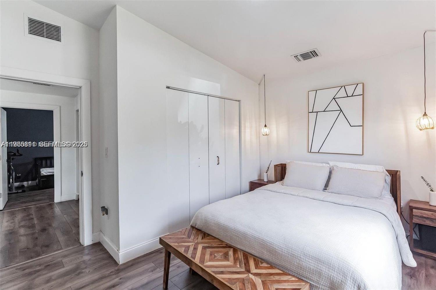 944 Northwest 64th Street Miami, FL 33150 - Photo 13 of 19 a bedroom with a bed and wooden floor