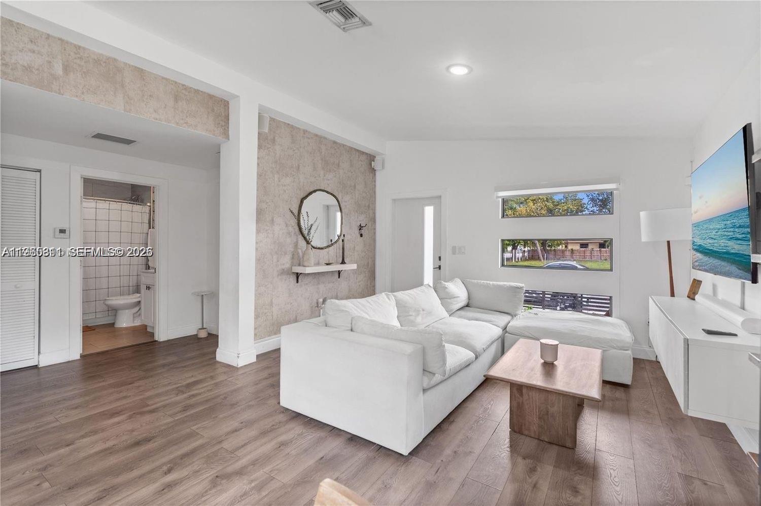 944 Northwest 64th Street Miami, FL 33150 - Photo 2 of 19 a living room with furniture and a large window