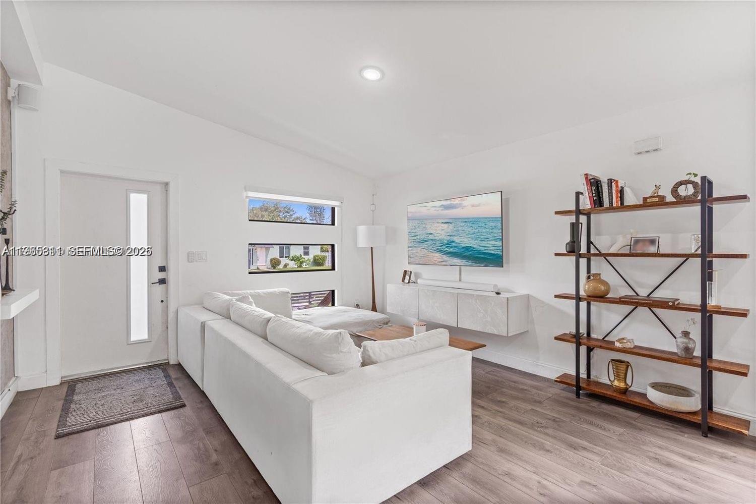 944 Northwest 64th Street Miami, FL 33150 - Photo 3 of 19 a living room with furniture and a flat screen tv