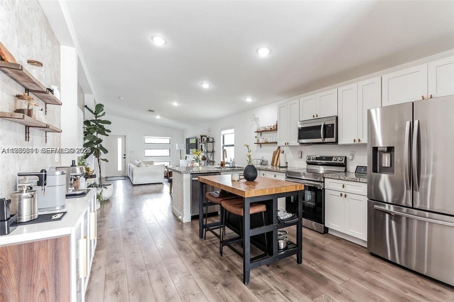 944 Northwest 64th Street Miami, FL 33150 - Photo 9 of 19 a kitchen with a sink a counter top space stainless steel appliances and cabinets