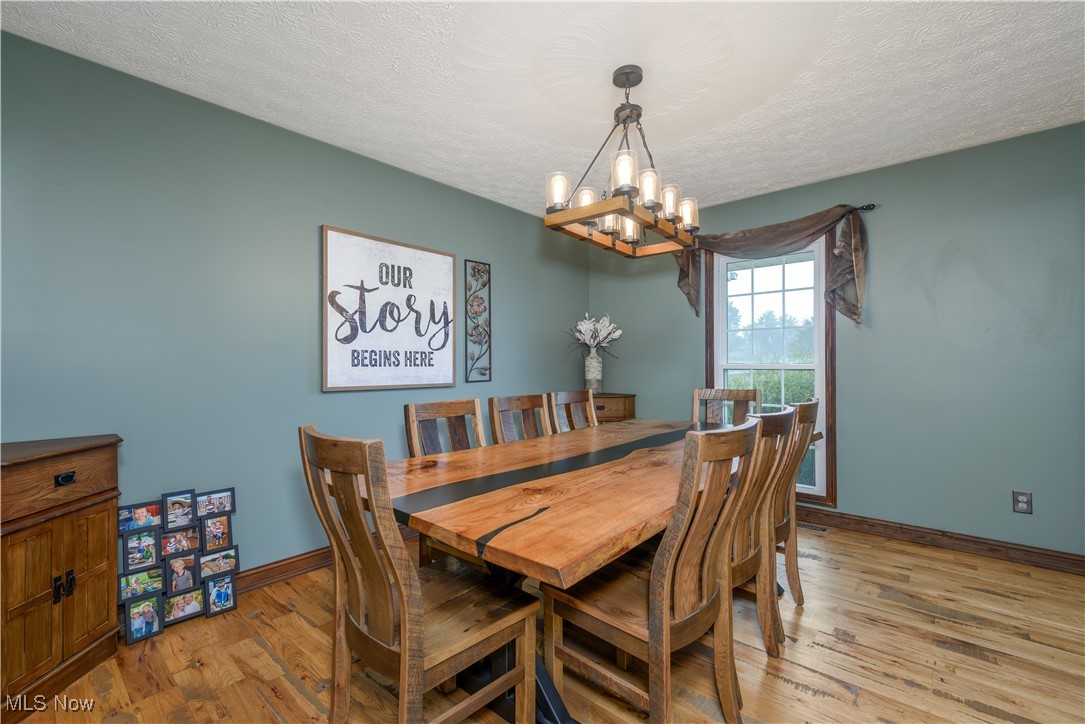 9715 Williams Road Diamond, OH 44412 - Photo 45 of 48 Dining room with an inviting chandelier, a textured ceiling, and light wood-type flooring