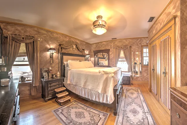 a bedroom with a bed lamps and couches