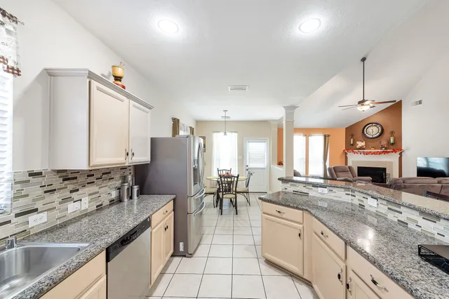 a kitchen with granite countertop a sink a counter top space appliances and cabinets