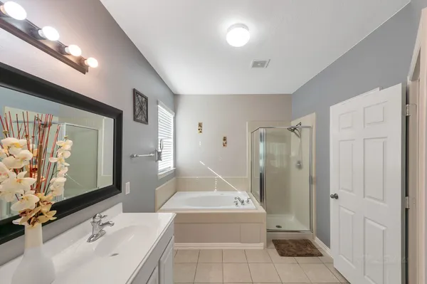 a bathroom with a tub sink and mirror