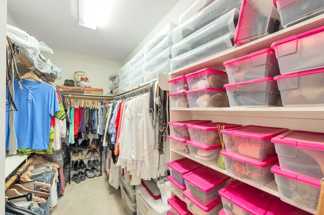 a view of walk in closet with clothes