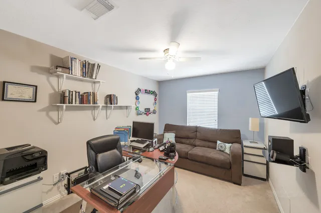 a living room with furniture a flat screen tv and kitchen view